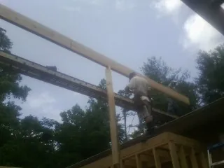 Carpenter setting a ridge beam over a new addition frame — Ice Dam Removal by Roofing Brothers in Sebeka