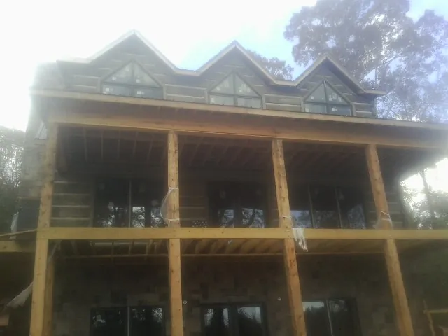 Dormers and porch framing on a large log home under construction — Roof Coating work by our crew in Sebeka