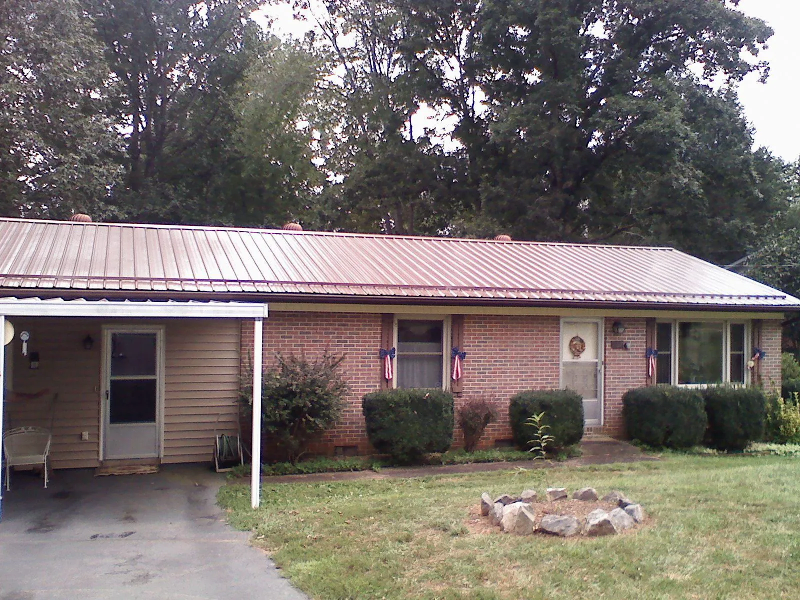 Bronze metal roof and carport on a brick ranch home — Roof Repair work by our crew in Sebeka